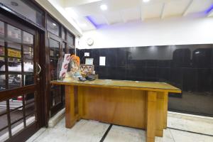 Super OYO Hotel Maa Residency في جامو: طاولة خشبية في غرفة مع كونتر