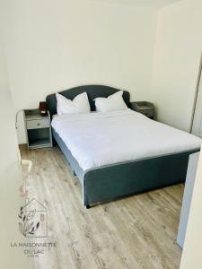 ein Schlafzimmer mit einem großen Bett mit weißer Bettwäsche in der Unterkunft Maison avec accès au lac in Izon