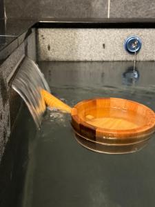 a wooden bowl in the water with a hose at 礁溪樂沐L’Amour in Yü-shih-ts'un