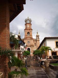 an old church with a clock tower in a street at Casa Romance Escondido in Puerto Vallarta