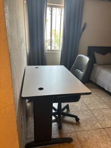 薩爾蒂約的住宿－Habitación Roble，一张桌子和一把椅子,位于一个配有床的房间