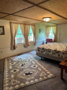 ein Schlafzimmer mit einem Bett und einem Teppich auf dem Boden in der Unterkunft Bailey wick farm Jackson river retreat in Covington