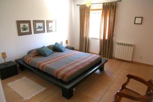 a bedroom with a bed and a chair and a window at Villa Casa Dina in Casal da Lagoa Seca +68 photos