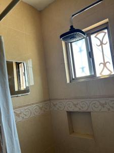 a bathroom with a shower and a window at Habitación Roble in Saltillo