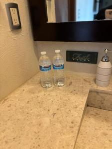 dos botellas de agua sentadas encima de un mostrador en Habitación Roble, en Saltillo