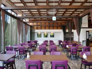 大牟田市にあるホテル ニューガイア オームタガーデンの紫色の椅子とテーブルが備わるダイニングルーム