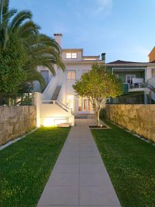 a house with a walkway in front of a yard at Uporto House Villa in Porto