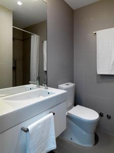 a bathroom with a sink and a toilet and a mirror at Uporto House Villa in Porto