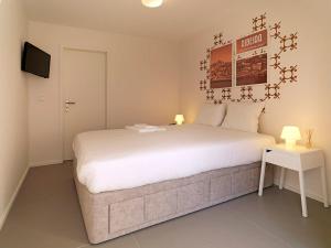 a bedroom with a large white bed and a television at Uporto House Villa in Porto