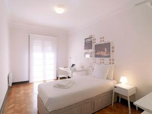 a white bedroom with a bed and a desk at Uporto House Villa in Porto