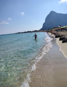 a man standing in the water at the beach at L'Isola nel Mare in San Vito lo Capo