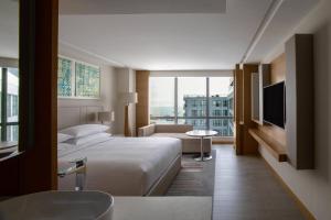 コタキナバルにあるコタキナバル マリオット ホテルのベッドとテレビが備わるホテルルームです。