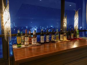a row of bottles of wine sitting on a bar at Hotel New Gaea Omuta Garden in Ōmuta +46 photos