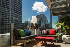 蒙特婁的住宿－蒙特利爾市中心萬麗酒店，一个带两把椅子和一张桌子的阳台,一个城市