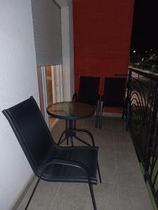 a table and chairs in a room with a balcony at Vukov Apartman in Banja Koviljača