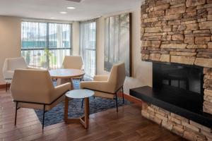 a waiting room with chairs and a fireplace at Fairfield by Marriott Inn & Suites Wallingford New Haven in Wallingford