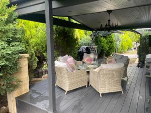 a patio with a table and chairs under an umbrella at Juniper Corner-Hunter Valley-A Step back in time!-7 mins to Vineyards in Cessnock