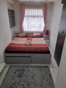 una camera con un letto con finestra e un tappeto di Apartement Grand Asia Afrika Residence Bandung a Bandung