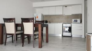 a kitchen with a table and chairs and appliances at Depto moderno a estrenar!!! in Comodoro Rivadavia