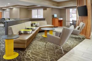 vestíbulo con sofá y 2 mesas y sillas en SpringHill Suites Raleigh-Durham Airport/Research Triangle Park en Durham