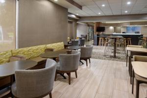 a restaurant with tables and chairs and a bar at SpringHill Suites Raleigh-Durham Airport/Research Triangle Park in Durham