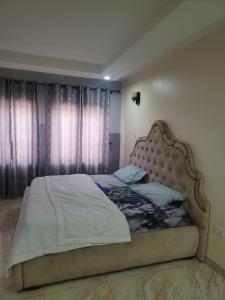 ein Schlafzimmer mit einem großen Bett mit einem großen Fenster in der Unterkunft CHIKALVIA GUEST HOUSE in Karsana