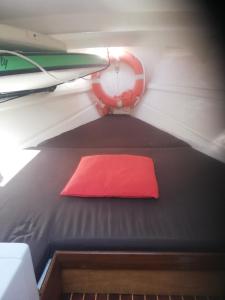 a red pillow on a bed in a boat at Sleep in the bay on my boat in Porto San Paolo