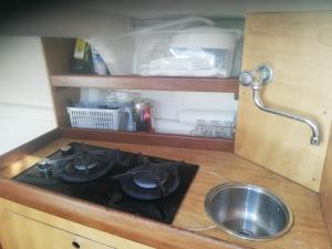 a kitchen counter with a stove and a sink at Sleep in the bay on my boat in Porto San Paolo