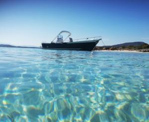 a boat sitting in the water next to a beach at Sleeping on a boat in the Island's bay in Porto San Paolo +59 photos