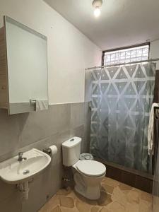 uma casa de banho com um WC, um lavatório e um chuveiro em Daniel Apartment em Guayaquil