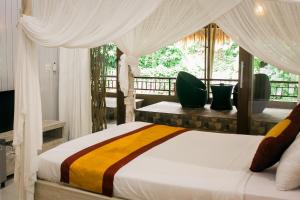 a bedroom with a bed with a canopy at Kubuku Ubud Villas in Ubud