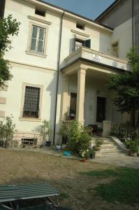 a large white building with a balcony and a table at Le Maddalene in Verona