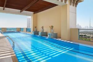 Marriott Hotel Al Jaddaf, Dubai في دبي: مسبح كبير في مبنى به نافذة كبيرة