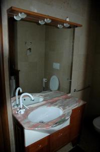 ein Badezimmer mit einem Waschbecken und einem großen Spiegel in der Unterkunft Le Maddalene in Verona