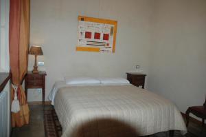 sypialnia z białym łóżkiem i 2 szafkami nocnymi w obiekcie Le Maddalene w Weronie