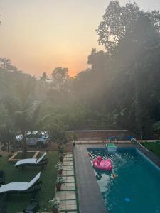 a swimming pool with a pink float in a backyard at Samrudhi Farm Resort in Kannādi +18 photos