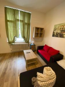 a living room with a red couch and a table at MINATO Apartments Ostrava center in Ostrava