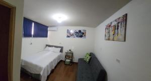 1 dormitorio pequeño con 1 cama y 1 sofá en GYWEL1214 3, en San Salvador