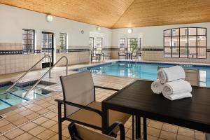 a swimming pool with a table with towels on it at Staybridge Suites Minneapolis-Maple Grove, an IHG Hotel in Maple Grove