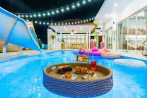 Una piscina con una mesa con comida encima. en Pool House Pool Villa Cha-Am, en Cha Am