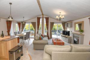 a living room with couches and a kitchen and a table at Lakewood retreat in Woodhall Spa