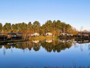 Blick auf einen See mit Häusern und Bäumen in der Unterkunft Lakewood retreat in Woodhall Spa