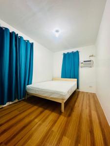 um quarto com uma cama e cortinas azuis em Villa catalina Bora 2 Resort em Nabas