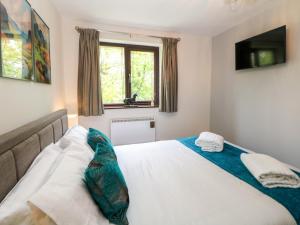 een slaapkamer met een groot wit bed en een raam bij Sylvannah in Buxton
