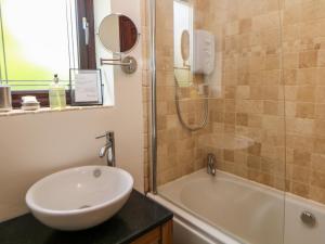 een badkamer met een wastafel en een ligbad bij Sylvannah in Buxton +25 foto's