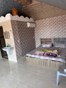 um quarto com uma cama numa parede de tijolos em Dream Bedouin life camp em Wadi Rum