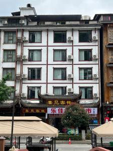 ein großes weißes Gebäude mit Fenstern in einer Stadt in der Unterkunft 张家界喜见客栈 in Zhangjiajie