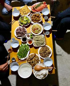 un tavolo con molti piatti di cibo sopra di Homestay Trúc Sơn a Hong Ha