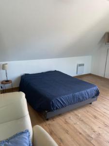 a bedroom with a bed and a couch at petit studio in Steenbecque