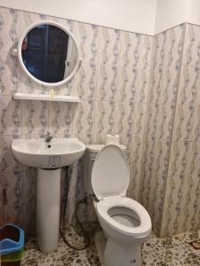 a bathroom with a toilet and a sink and a mirror at Phujhaofa villa club ( ไสยวน) in Ban Saiyuan (1)